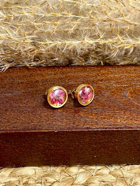 kleine ronde goudkleurige oorstekers met echte roze minibloempjes gegoten in hars. diameter 10mm