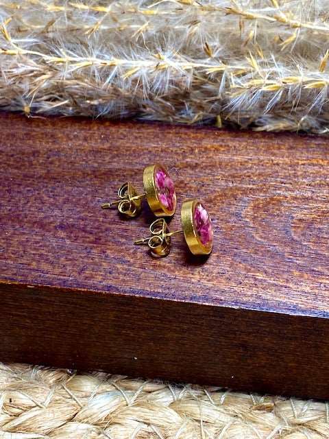 Botanische ronde goudkleurige oorstekers met echte roze minibloempjes gegoten in hars. diameter 10mm. materiaal stainless steel. zijaanzicht