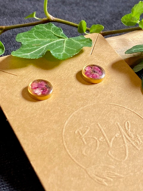 kleine ronde goudkleurige oorstekers met echte roze  minibloempjes gegoten in hars