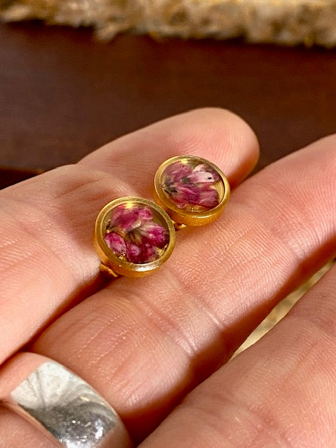 Botanische ronde goudkleurige oorstekers met echte roze minibloempjes gegoten in hars. diameter 10mm. materiaal stainless steel