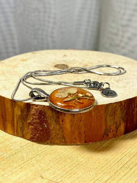 Round pendant with white flowers and amber birch bark.